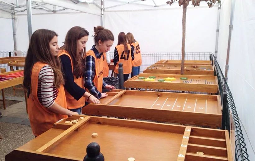 Niños y adultos jugando a juegos populares tradicionales en evento al aire libre